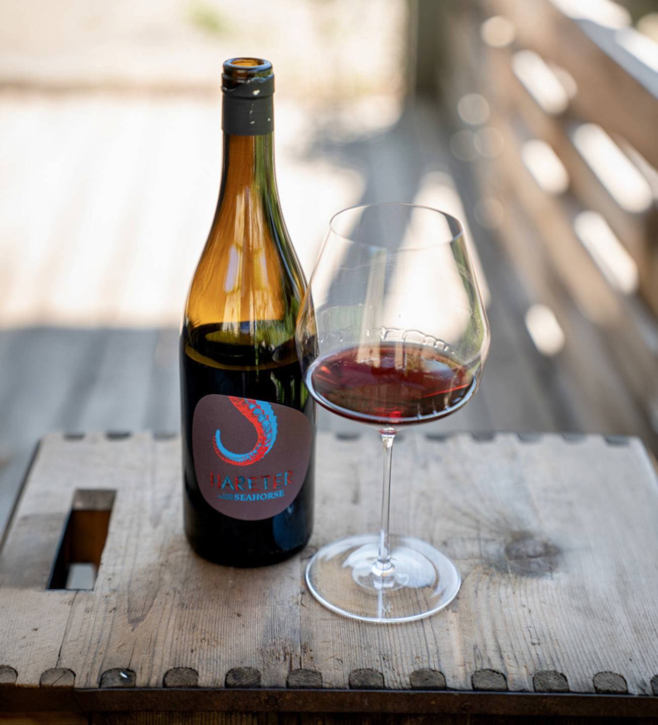 Weinflasche und gefülltes Weinglas beim Ab-Hof-Verkauf im Weingut Hareter in Weiden am See.